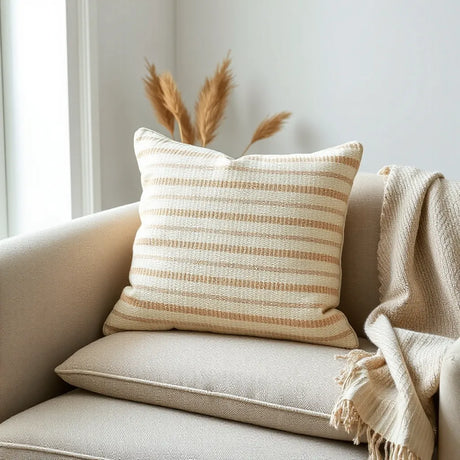 Striped grid woven cushion on a neutral sofa with textured fabric and soft, cozy styling