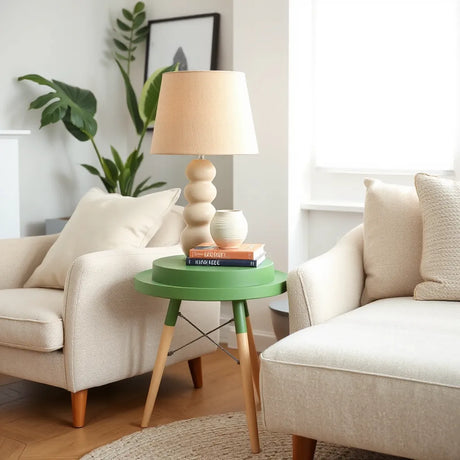 Modern green side table with lamp, vase and books in a bright living room